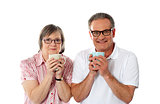 Romantic senior couple holding coffee mugs