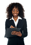 African female executive writing on notepad