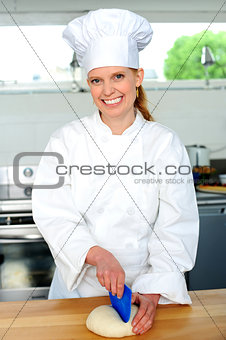 Female chef kneading bread dough