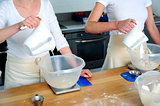 Females hand pouring water into flour bowl