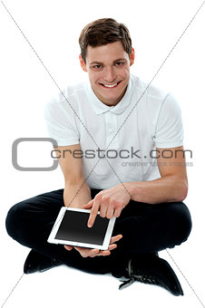 Seated guy with finger on touch pad device