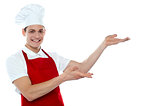 Male chef in red uniform presenting copy space