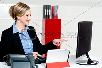 Female executive pointing at computer screen