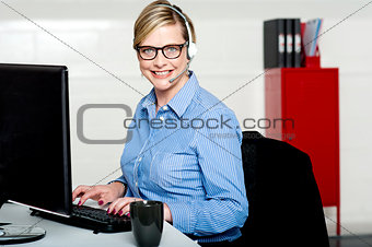 Smiling help desk woman typing on keyboard