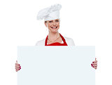 Matured cook presenting blank billboard