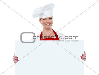 Matured cook presenting blank billboard