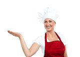 Smiling senior cook showing copy space