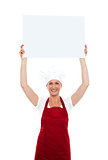 Chef holding advertising board over her head