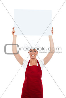 Chef holding advertising board over her head