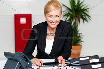Smiling corporate lady holding wireless tablet