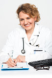 Happy female physician at work desk