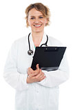 Smiling senior physician holding clipboard