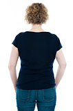 Rear view of curly haired stylish caucasian woman