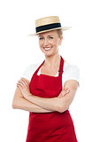 Confident cheerful female cook wearing hat