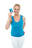 Trendy middle aged woman showing credit card