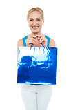 Happy aged woman carrying shopping bag