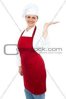Smiling cook presenting copy space, open palm