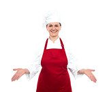 Senior female chef standing with open palms