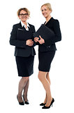 Aged businesswomen posing with documents