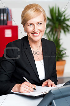 Female secretary writing on notepad