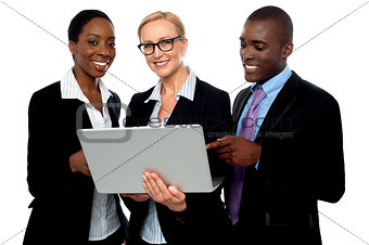 Team of friendly business people using laptop
