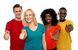 Smiling team of young people showing thumbs up