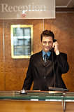 Profile shot of a handsome receptionist on the phone