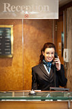 Attractive young receptionist receiving calls