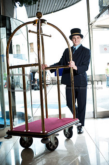 Profile shot of a doorman holding a cart