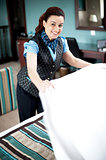 Charming hotel hostess changing the sheets