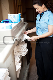 Back-office female employee folding sheets