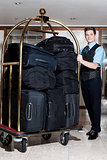 Concierge with a pile of bags in luggage cart