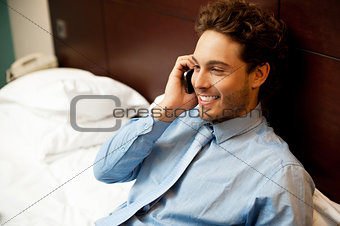 Young man conversing on mobile phone