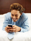 Cheerful man enjoying reading funny messages