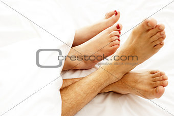 Closeup of bare feet of love couple, making out
