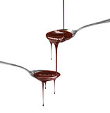 chocolate syrup dripping from a spoon on a spoon on a white back