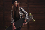 Hipster girl in glasses and with skateboard