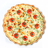 Quiche with cherry tomatoes and herbs on a white plate