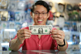 Happy Chinese Man Showing First Dollar Earning In Computer Shop