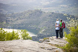 Young couple with toddler boy standing on cliff and enjoying view below