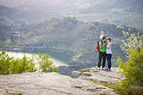 Young couple with toddler boy standing on cliff and kissing