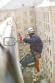 Industrial climber lowering from a roof of a building