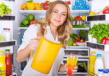 Happy woman pouring juice