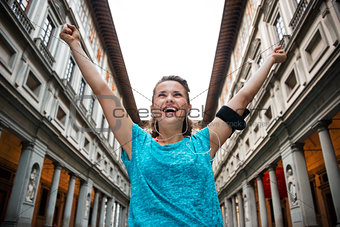 Happy fitness woman rejoicing near uffizi gallery in florence, i