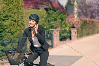 Businesswoman on a Bicycle Calling on her Phone