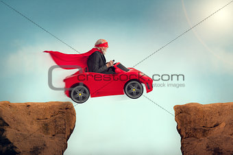 senior superhero driving a car off a ravine 