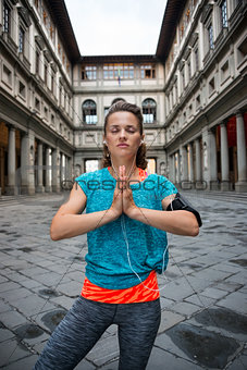 Fitness woman doing yoga near uffizi gallery in florence, italy