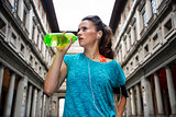 Fitness woman drinking water near uffizi gallery in florence, it