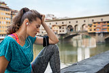 Fitness woman sitting near ponte vecchio in florence, italy