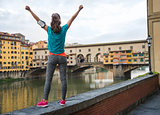 Fitness woman rejoicing in front of ponte vecchio in florence, i